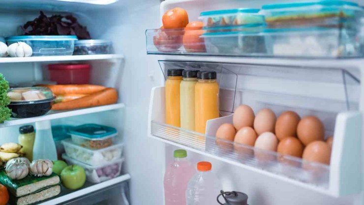 Frigo aperto con alimenti ben distribuiti