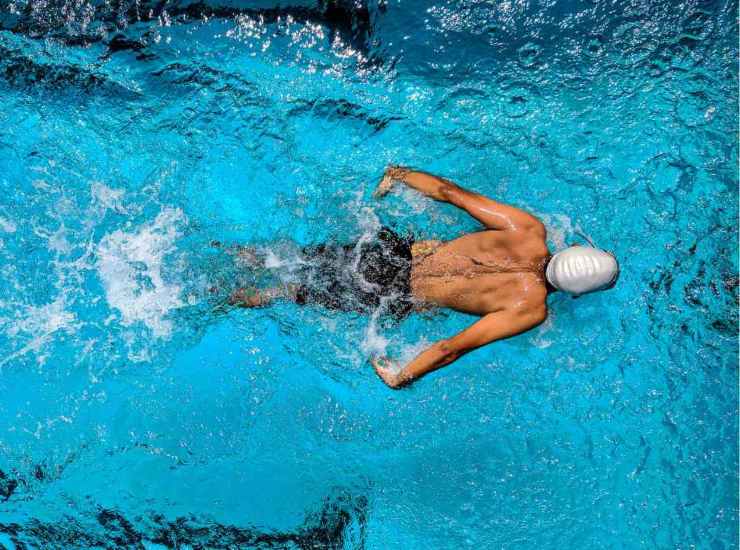 Uomo che nuota in piscina