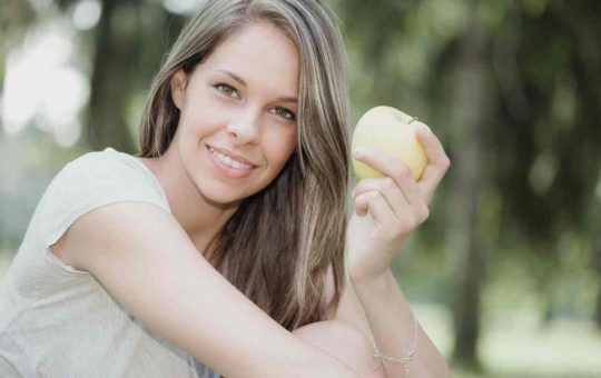 Ragazza sorridente con la mela