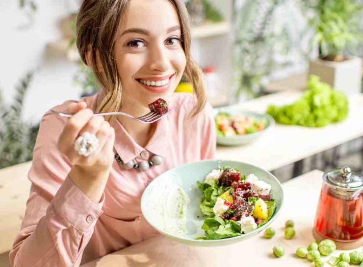 Giovane donna mangia un piatto ricco di nutrienti